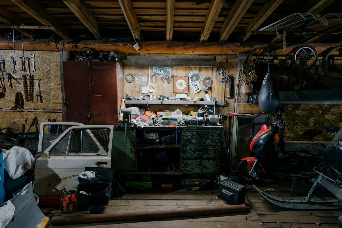 Cluttered garage workshop packed with tools, a workbench, and years of accumulated items
